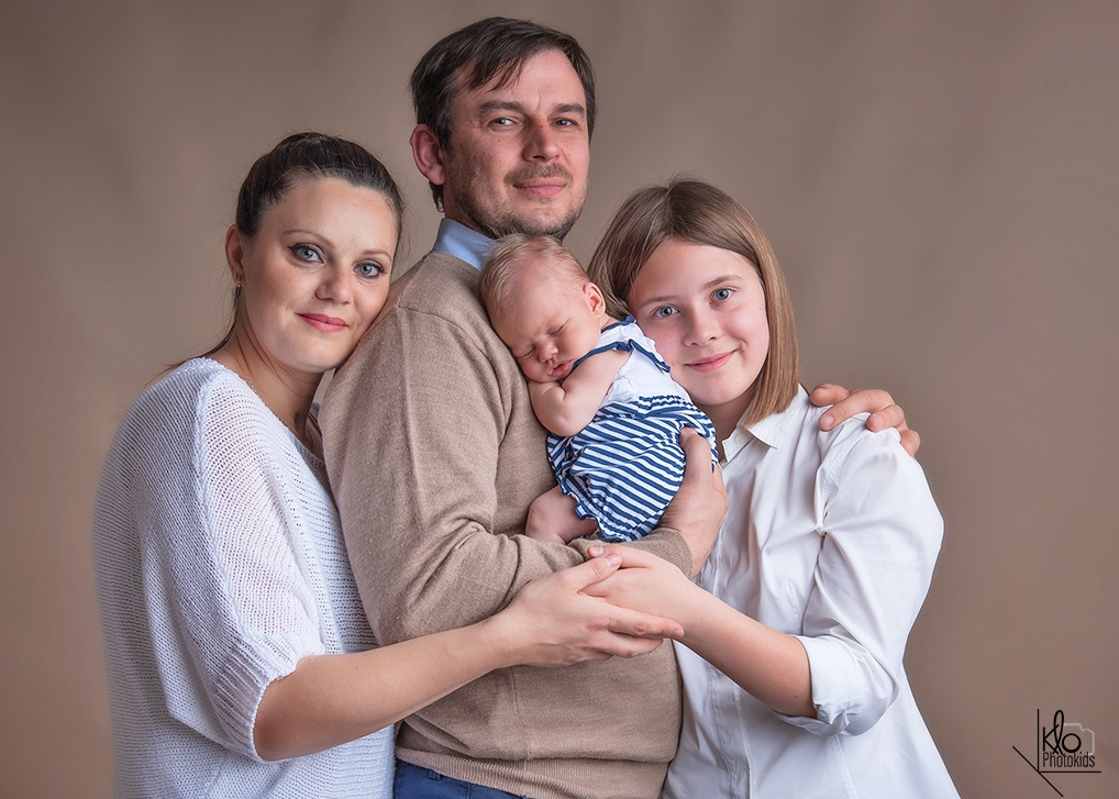 mamma e papà  tengono in braccio la neonata per le prime foto durante la sessione fotografica di famiglia presso fotografa klophotokids