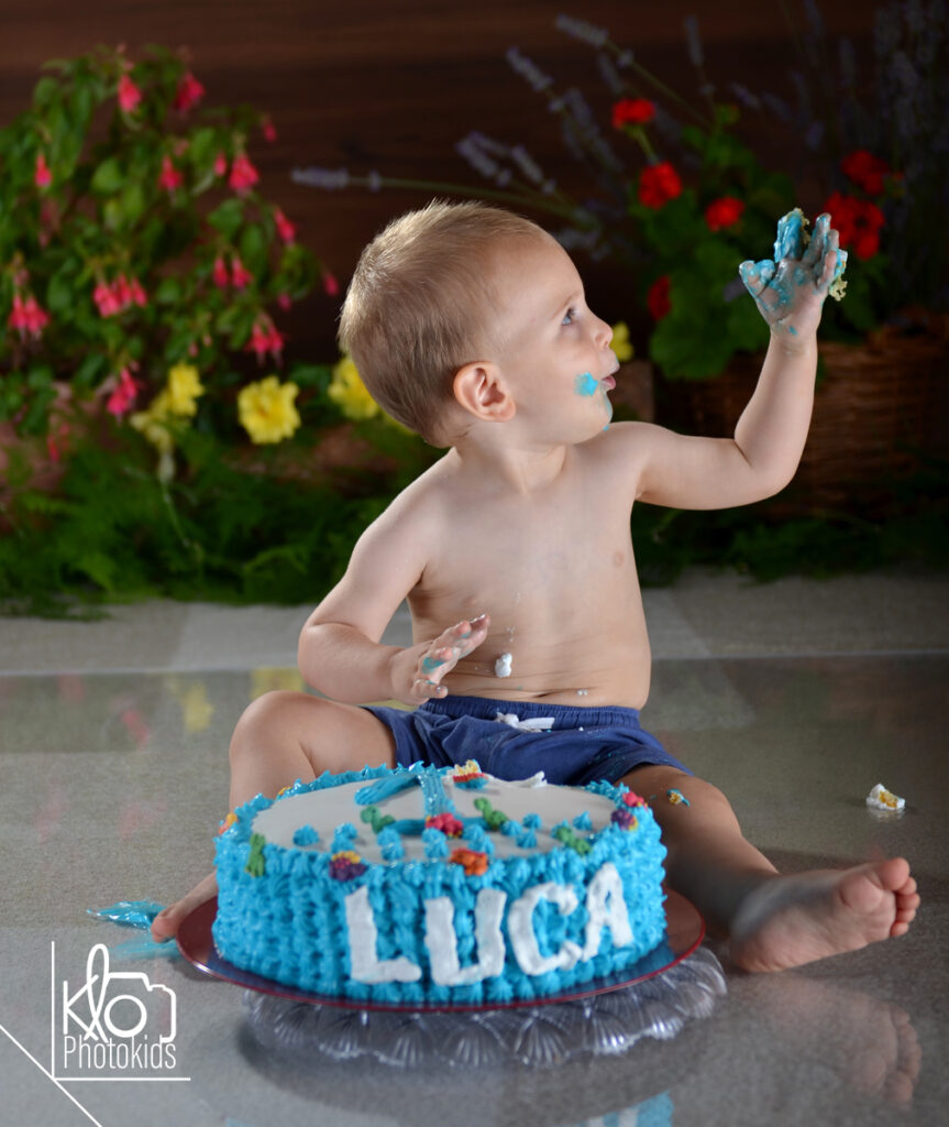 Servizio fotografico di smash cake Asti e provincia.bambino che gioca con la torta durante il suo servizio fotografico per il primo compleanno o smash cake