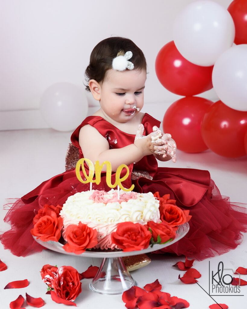 Servizio fotografico di smash cake Asti e provincia.bambina che gioca con la torta durante il suo servizio fotografico per il primo compleanno o smash cake