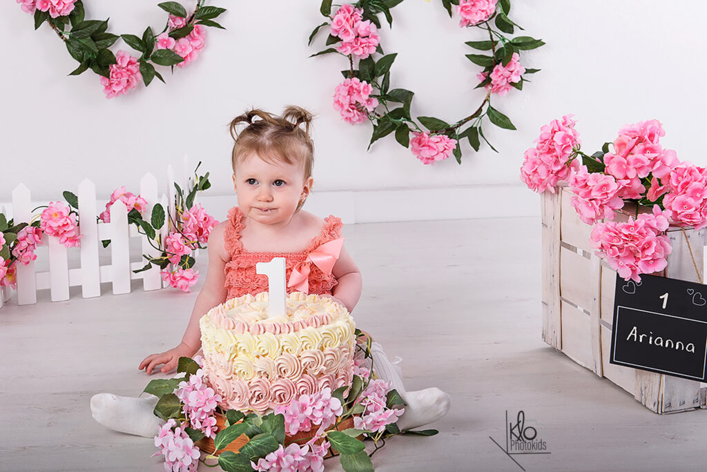 Servizio fotografico di smash cake Asti e provincia. bambina che gioca con la torta durante il suo servizio fotografico per il primo compleanno o smash cake