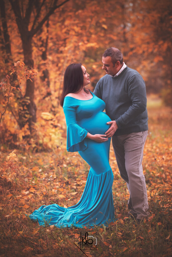 mamma e papà in dolce attesa durante il servizio fotografico di gravidanza all'aperto, abbraciando e accarezzando la pancia
presso fotografa klophotokids, asti e provincia