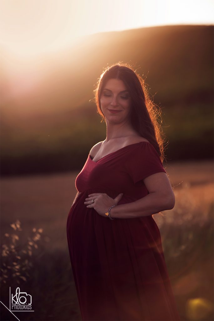 mamma in dolce attesa durante il servizio fotografico di gravidanza all'aperto, abbraciando e accarezzando la pancia
presso fotografa klophotokids, asti e provincia