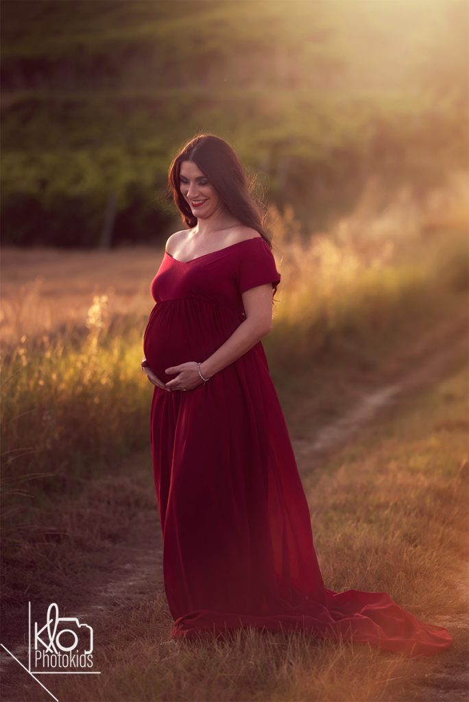 mamma in dolce attesa durante il servizio fotografico di gravidanza all'aperto, abbraciando e accarezzando la pancia
presso fotografa klophotokids, asti e provincia