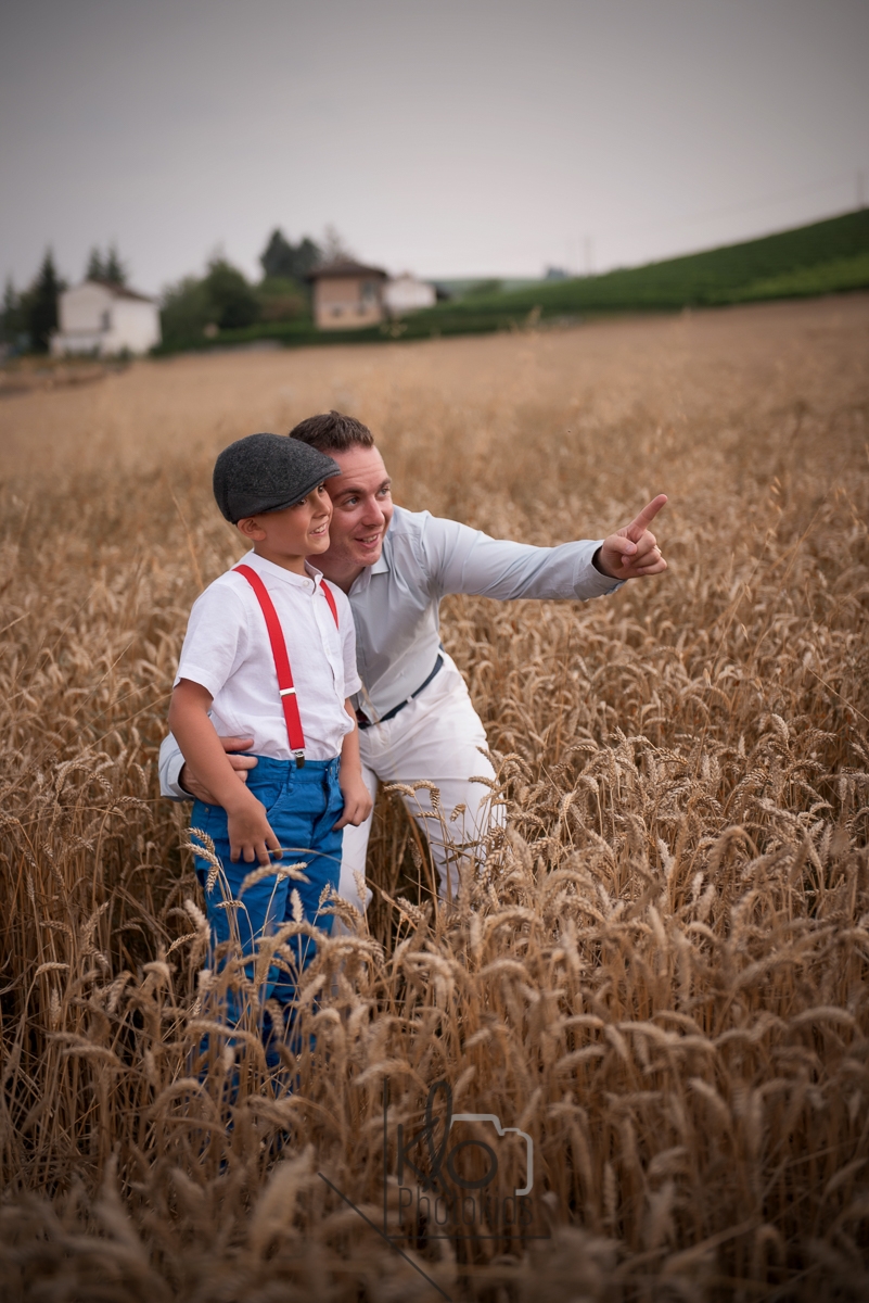 servizio fotografico di famiglia in un campo di grano. papà e figlio mentre parlano