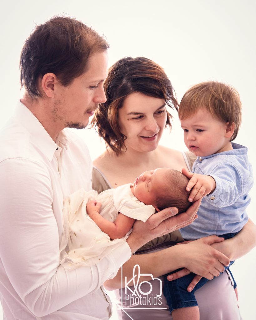 mamma e papaà  tengono in braccio la neonata per le prime foto durante la sessione fotografica di famiglia